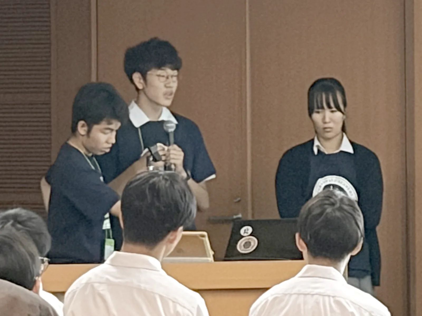 演台に並び、マイクを持って発表するユモッティズ（E班）