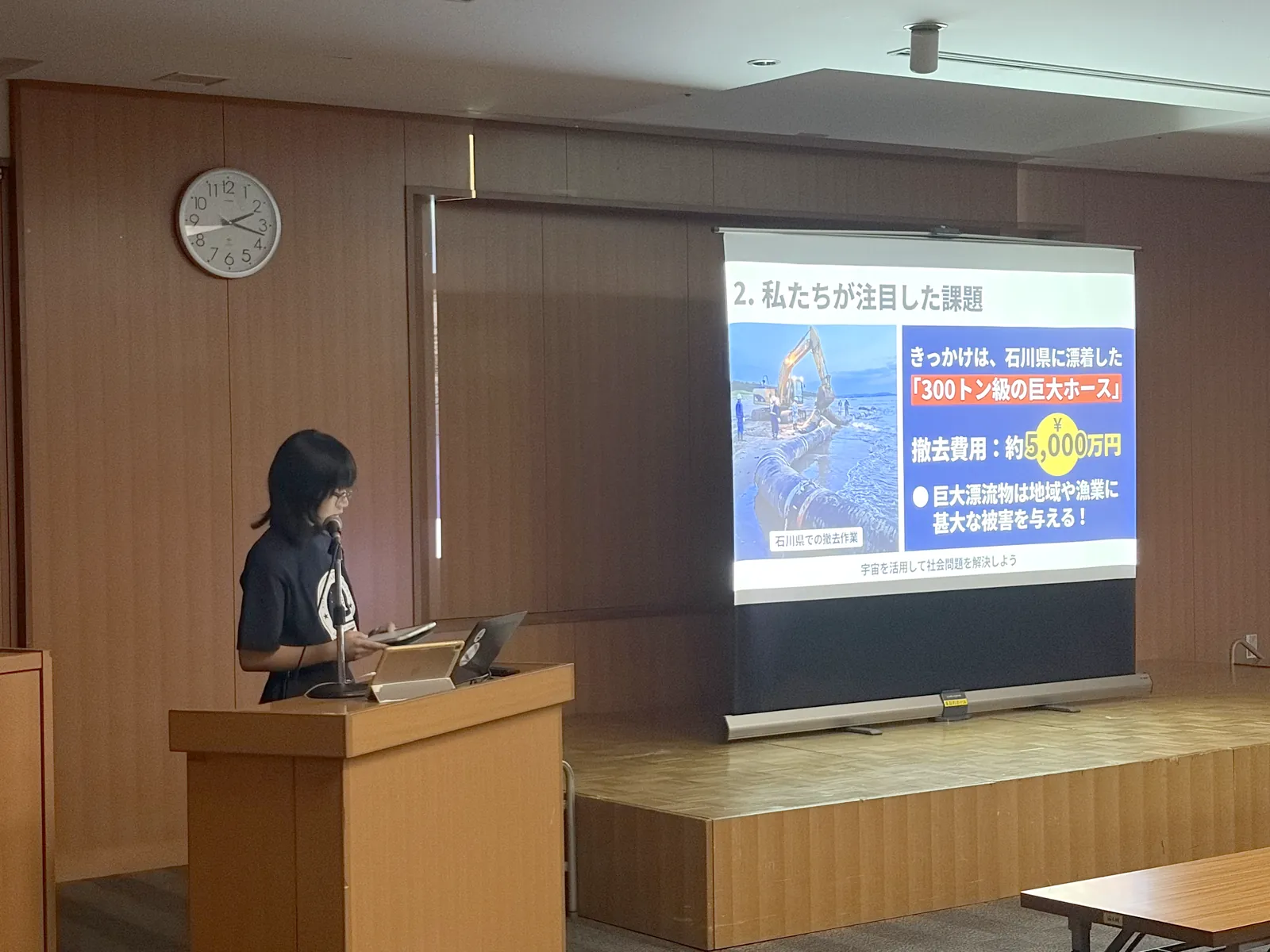 スライド「私たちが注目した課題」を映しながら発表するA班の発表者